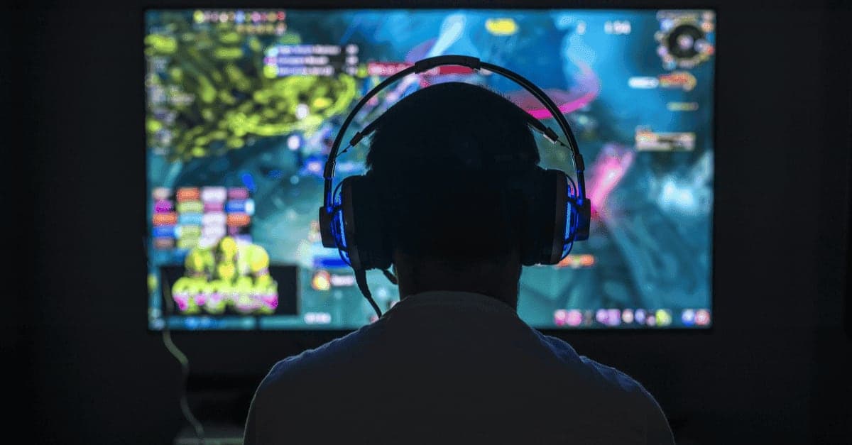 Gamer mit Headset vor einem Bildschirm mit Online-Spiel