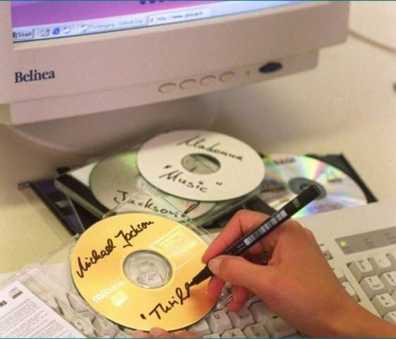 Selbst gebrannte CDs werden vor einem Computer von Hand beschriftet